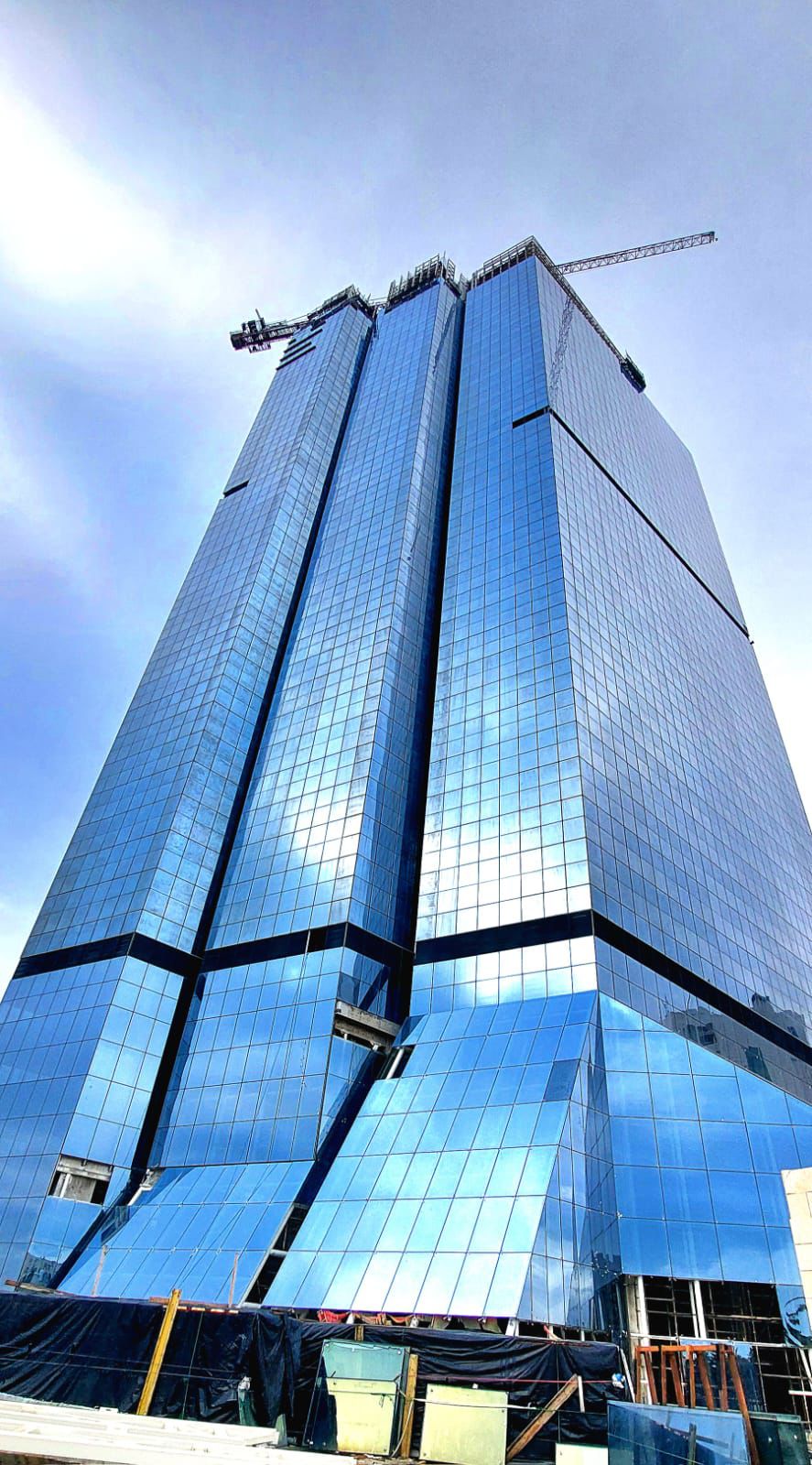 Blue glass Jordan Gate tower rising above the construction site